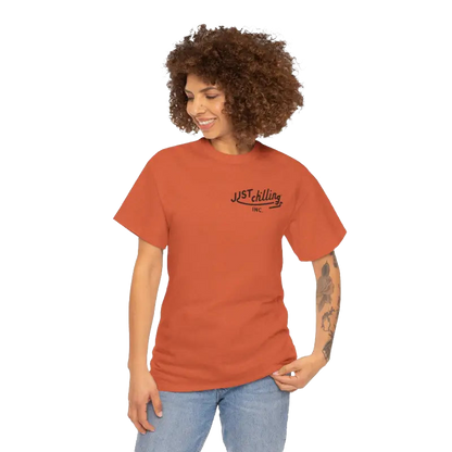 A smiling woman with curly hair wearing an orange t-shirt with text on it.