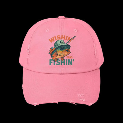 A pink baseball cap with a graphic of a fish wearing a hat and sunglasses, along with the text "Wishin' I was FISHIN'" printed on it.