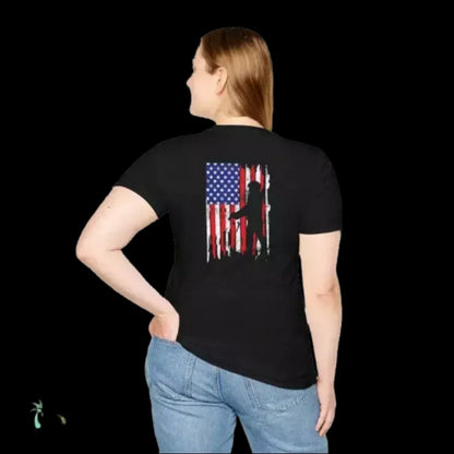 A woman wearing a black t-shirt with an American flag design on the back, standing against a black background.