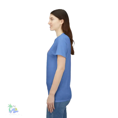 A woman wearing a blue t-shirt and jeans is standing against a black background.