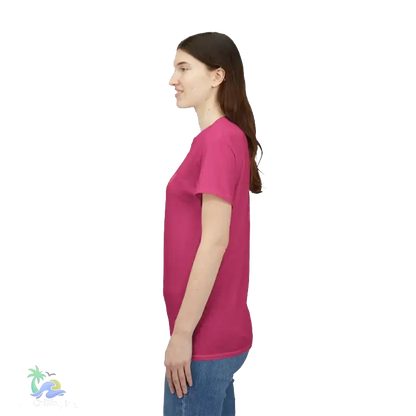 A woman wearing a pink t-shirt stands against a black background.