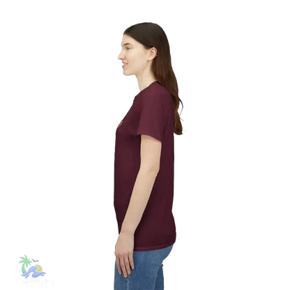 A woman wearing a maroon t-shirt stands against a black background.