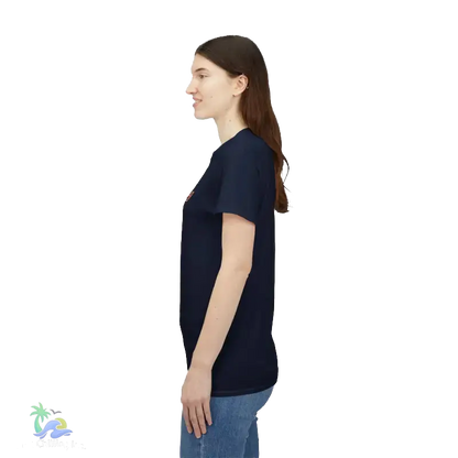 A woman with long brown hair is standing in profile, wearing a navy blue t-shirt and blue jeans.