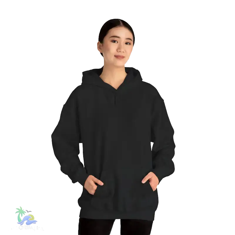 A woman wearing a black hoodie stands against a black background.