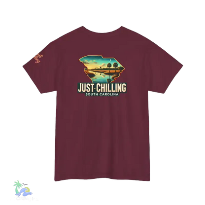 A maroon t-shirt with a graphic design depicting a scenic landscape with a lake and mountains, along with the text "Just Chilling South Carolina" printed on it.