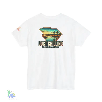 A white t-shirt with a graphic design depicting a scenic landscape with a body of water and palm trees. The text on the t-shirt reads "Just Chilling South Carolina".