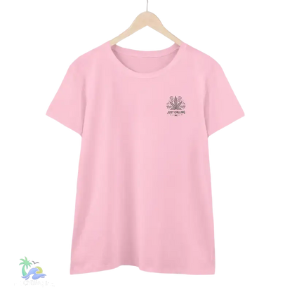 A pink t-shirt with a graphic design on the front, hanging on a wooden hanger.